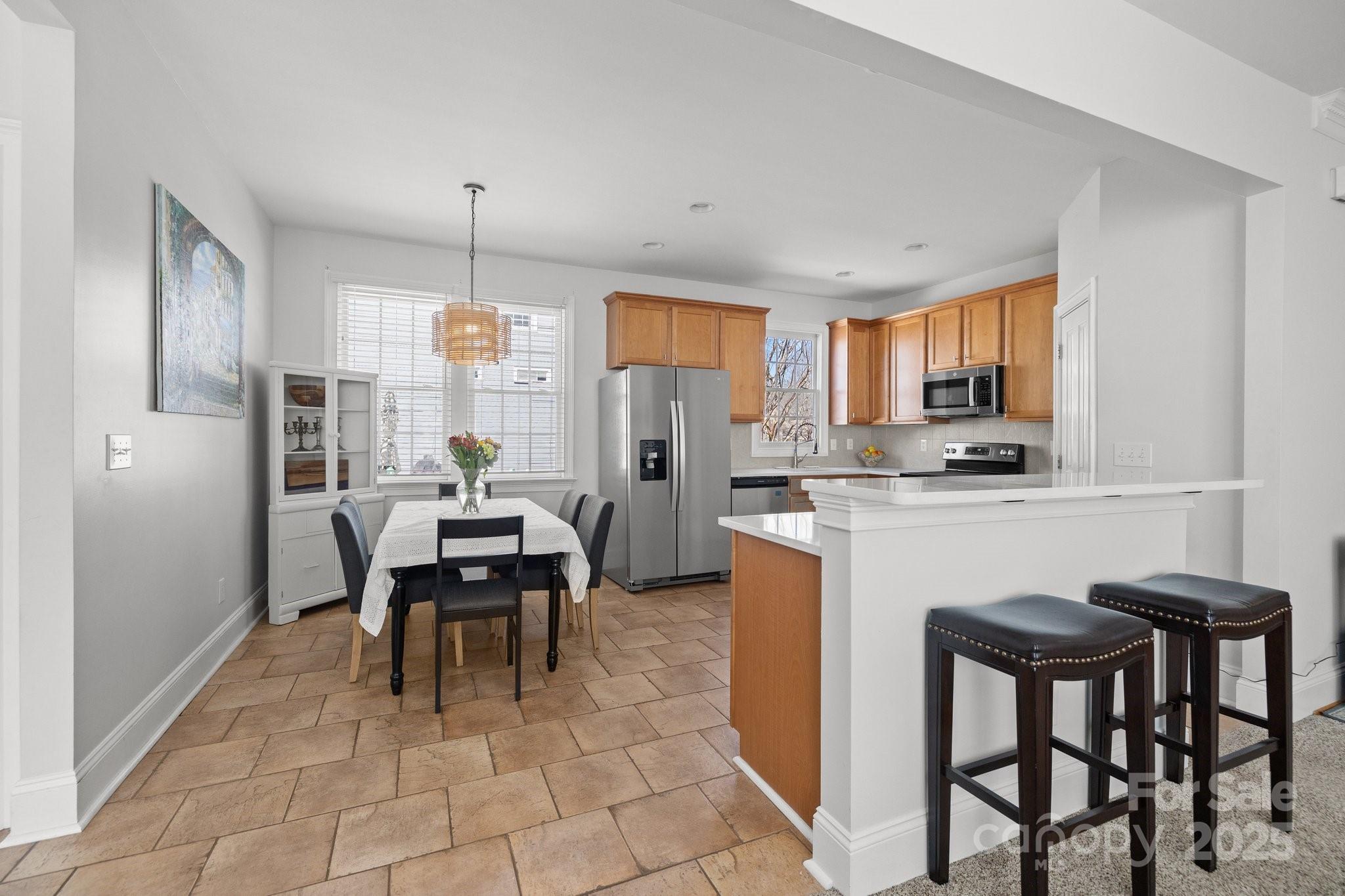 3208 Fifth Baxter Crossing Fort Mill, SC 29708 - Photo 14 of 38 a kitchen with kitchen island granite countertop wooden cabinets and a refrigerator