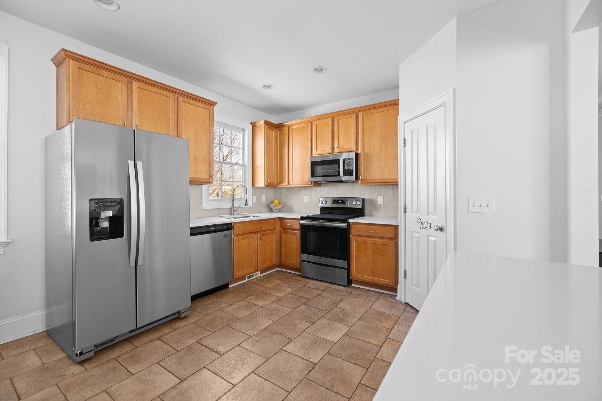3208 Fifth Baxter Crossing Fort Mill, SC 29708 - Photo 15 of 38 a kitchen with stainless steel appliances a refrigerator sink and cabinets