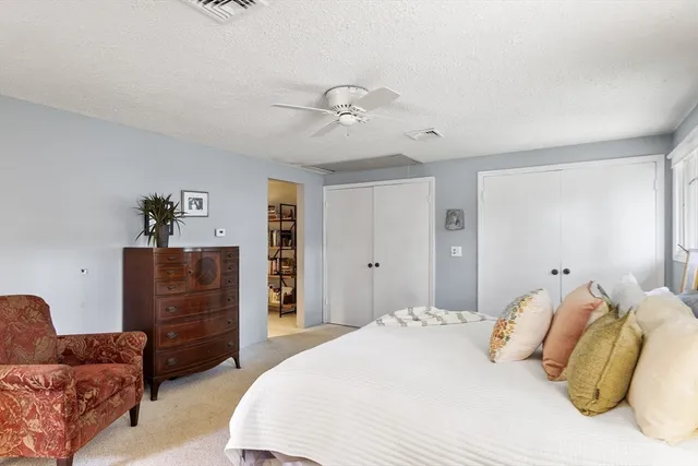 a spacious bedroom with a bed and dresser