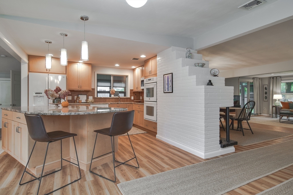 52 Lohnes Road Framingham, MA 01701 - Photo 6 of 34 a kitchen with stainless steel appliances kitchen island granite countertop a dining table chairs and a refrigerator