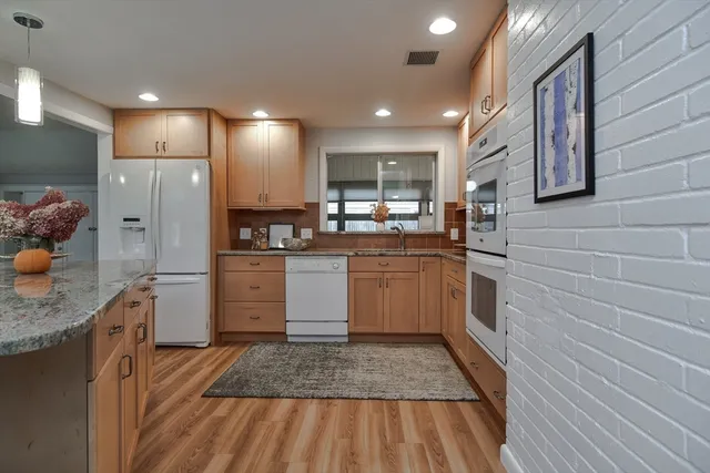a kitchen with stainless steel appliances granite countertop a stove a sink and a microwave