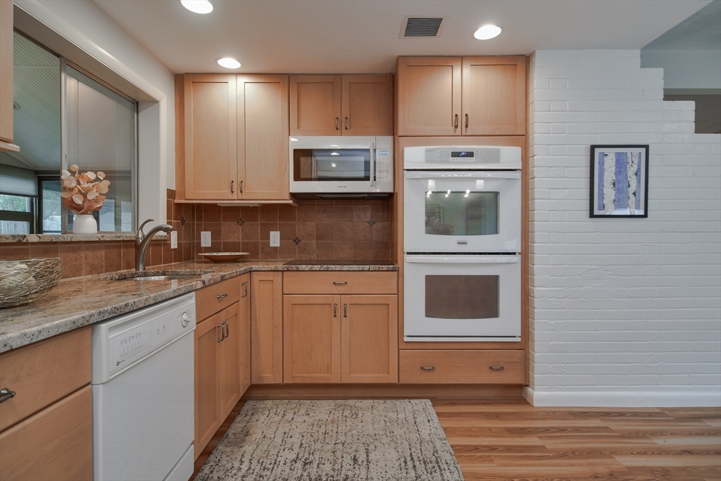52 Lohnes Road Framingham, MA 01701 - Photo 9 of 34 a kitchen with stainless steel appliances granite countertop a stove a sink and a microwave
