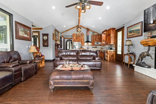 a living room with furniture fireplace and a large window