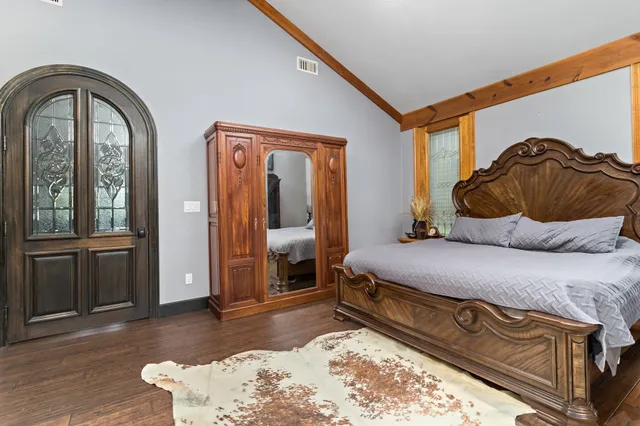 a bedroom with a bed and wooden floor
