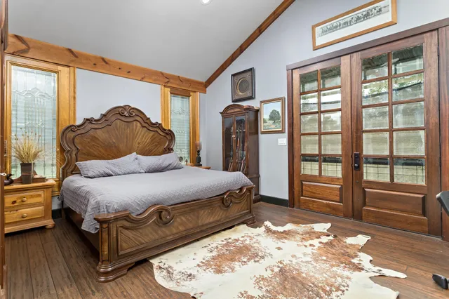 a spacious bedroom with a bed and glass windows