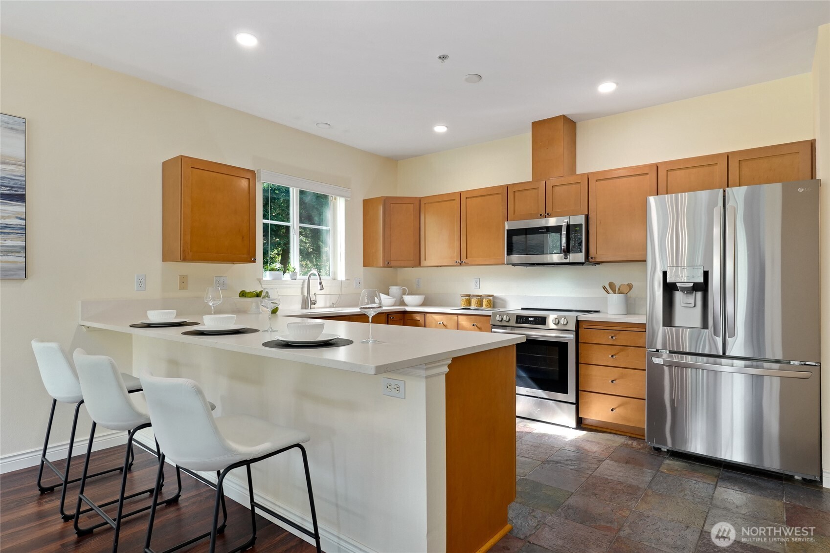 17432 Bothell Way Northeast, Unit B106 Bothell, WA 98011 - Photo 13 of 23 a kitchen with stainless steel appliances granite countertop a sink a stove a refrigerator and island with wooden floor