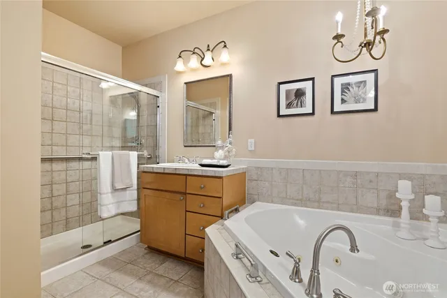 a bathroom with a double vanity sink mirror and bathtub