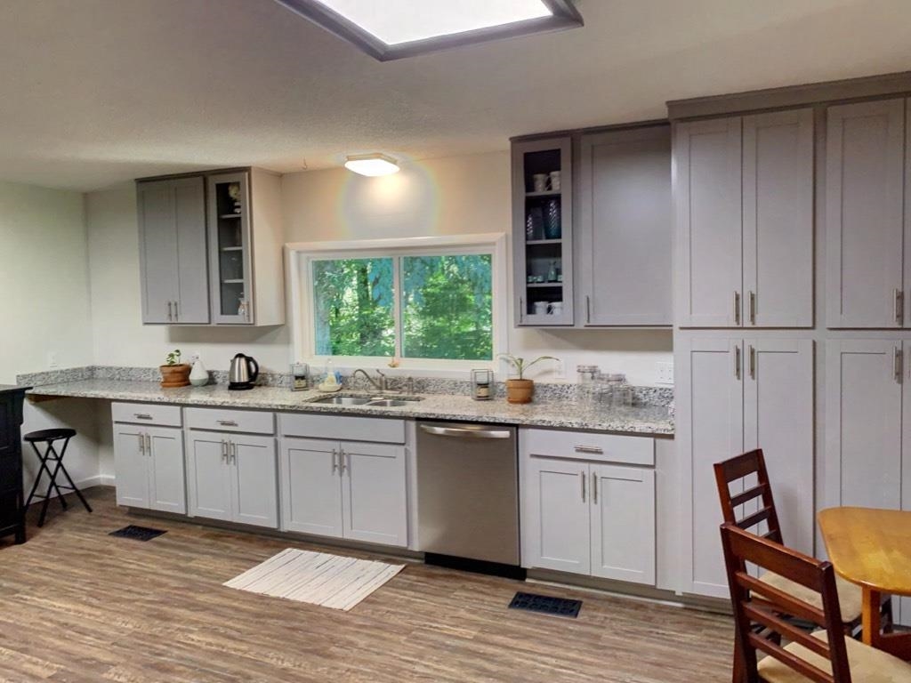 6546 Old Tipton Road Millington, TN 38053 - Photo 12 of 23 Kitchen with wood-type flooring, sink, light stone countertops, and stainless steel dishwasher
