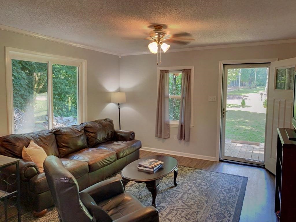 6546 Old Tipton Road Millington, TN 38053 - Photo 7 of 23 Living room with hardwood / wood-style flooring, ornamental molding, ceiling fan, and a textured ceiling