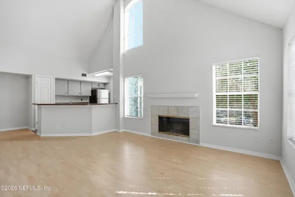 a view of empty room with a kitchen and fireplace