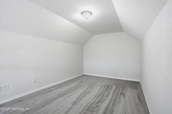 a view of room with walk in closet and wooden floor