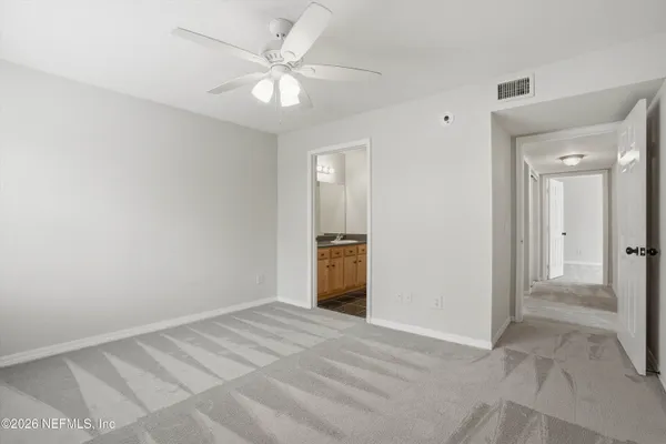 a view of a livingroom with a chandelier fan and windows
