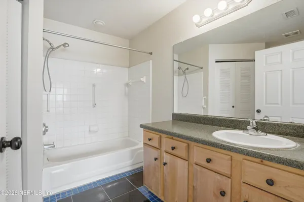 a bathroom with a sink double vanity granite tub shower and a mirror