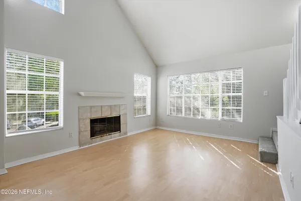 a view of an empty room with a window and fireplace