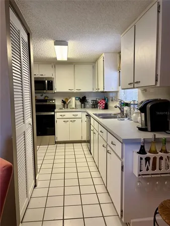 a kitchen with a sink a stove and cabinets