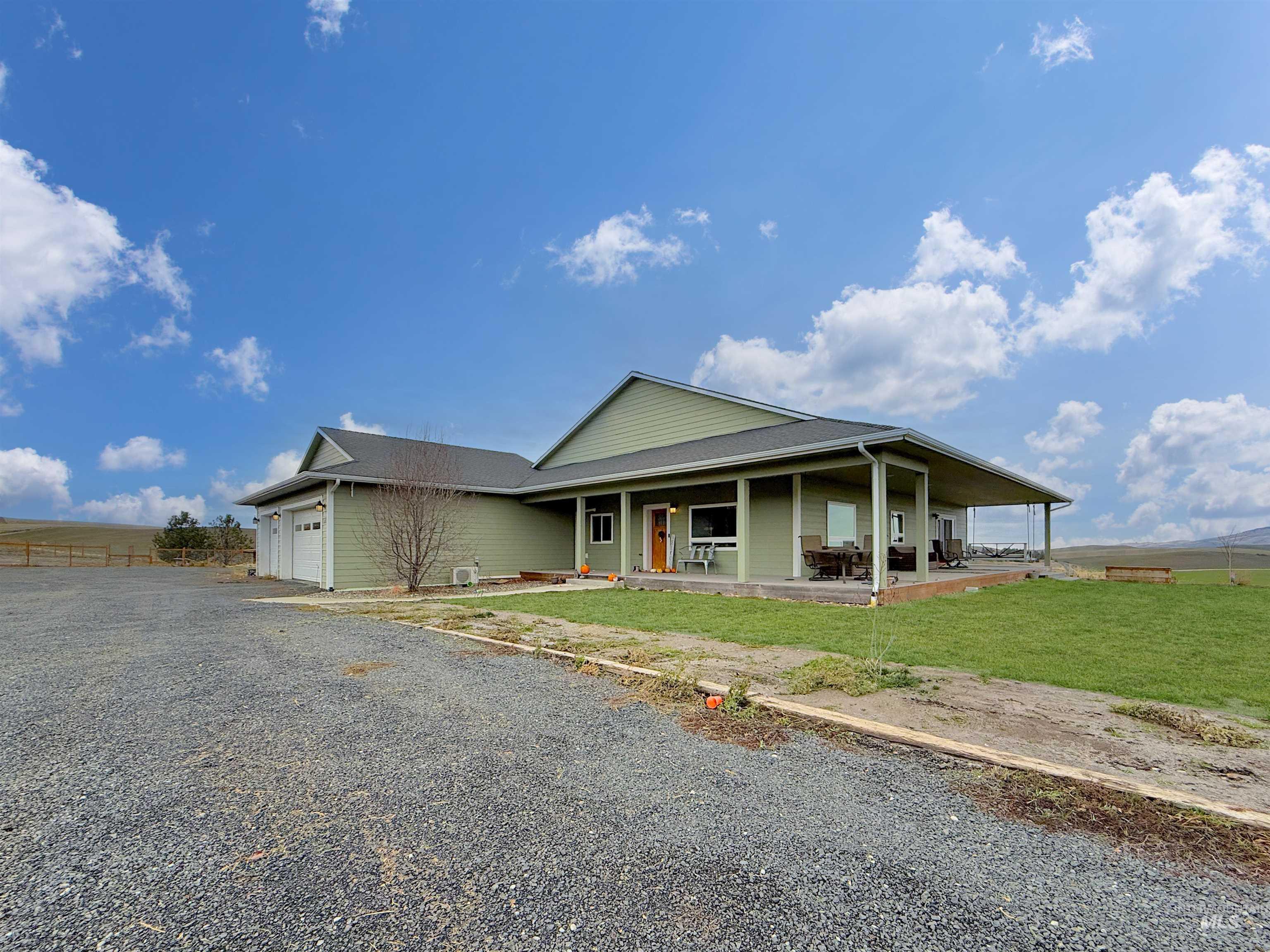 1030 Tempest Lane Viola, ID 83872 - Photo 1 of 37 View of front of property featuring an attached garage, covered porch, and gravel driveway
