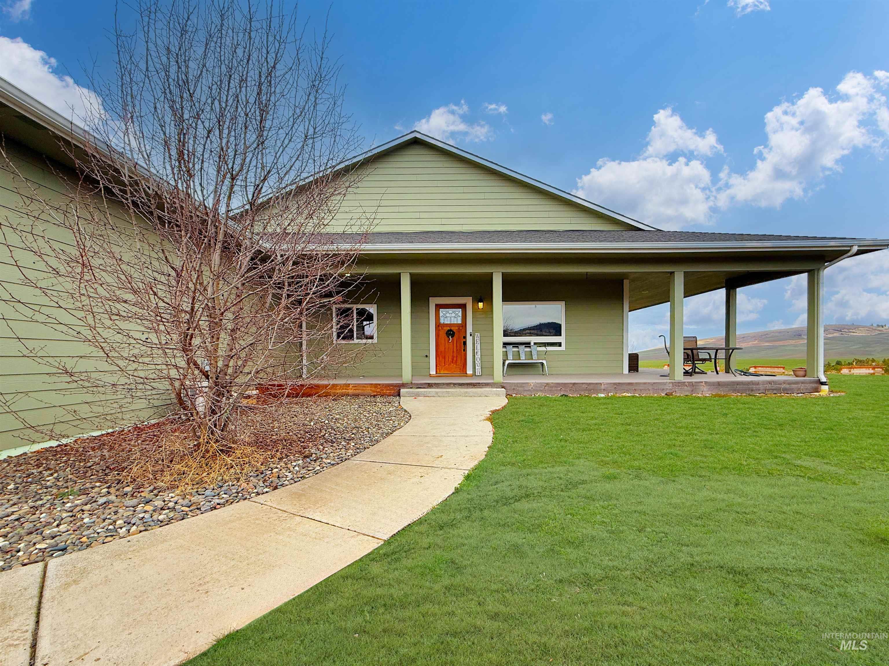 1030 Tempest Lane Viola, ID 83872 - Photo 2 of 37 View of front of house featuring covered porch, a front lawn, and roof with shingles
