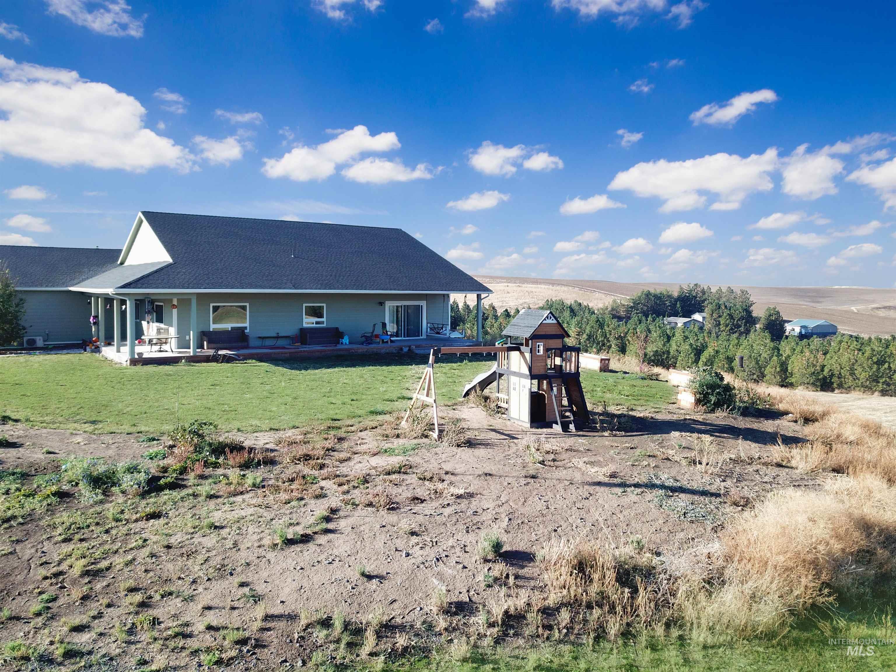 1030 Tempest Lane Viola, ID 83872 - Photo 27 of 37 Rear view of house with roof with shingles and a yard