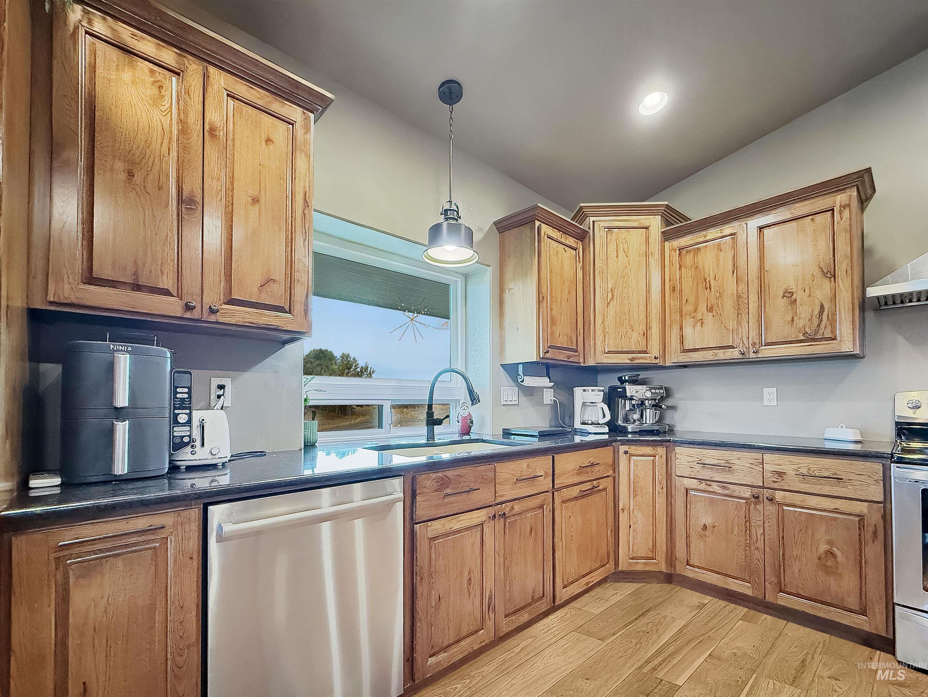 1030 Tempest Lane Viola, ID 83872 - Photo 9 of 37 Kitchen featuring dishwasher, range with electric stovetop, pendant lighting, light wood-style floors, and wood finish cabinetry