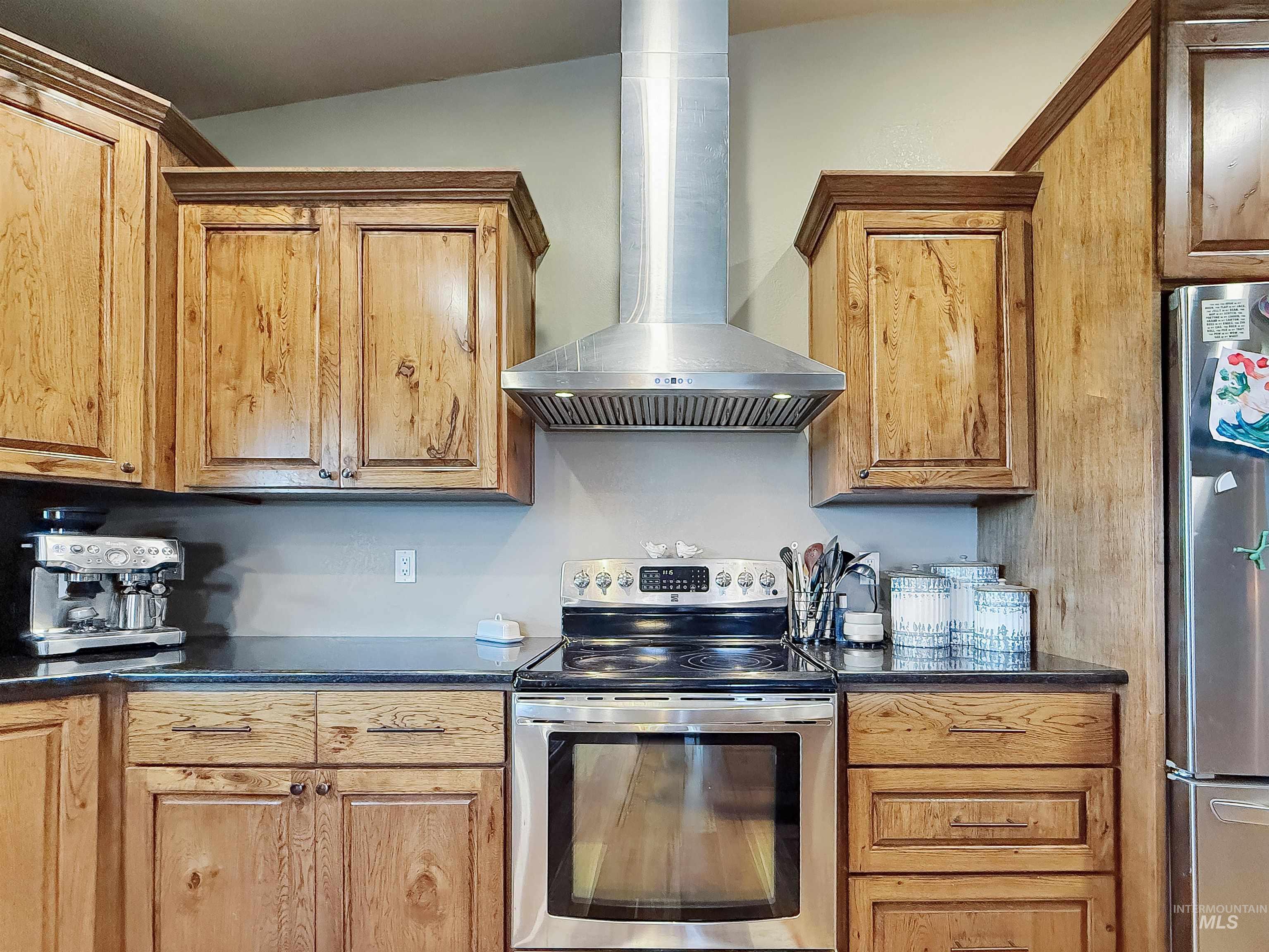 1030 Tempest Lane Viola, ID 83872 - Photo 10 of 37 Kitchen with stainless steel appliances, dark stone countertops, and wood finish cabinets