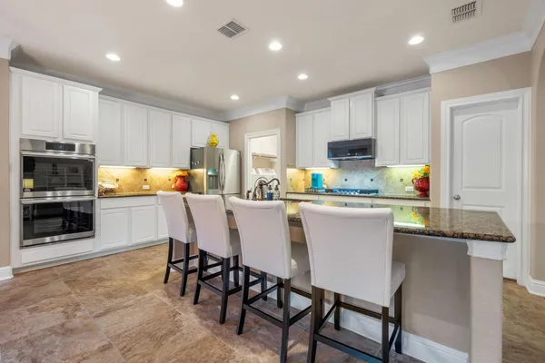 a kitchen with a dining table chairs microwave and refrigerator