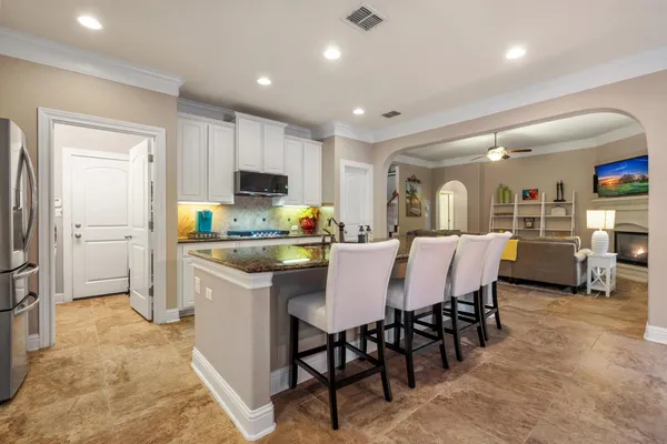 a kitchen with kitchen island granite countertop lots of counter top space and refrigerator