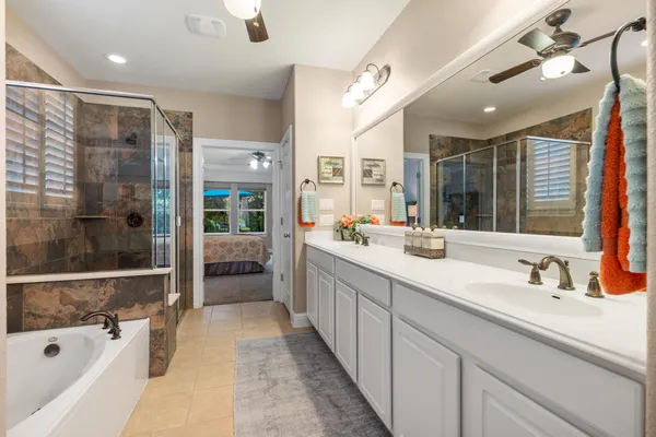 a bathroom with a tub sink shower and mirror