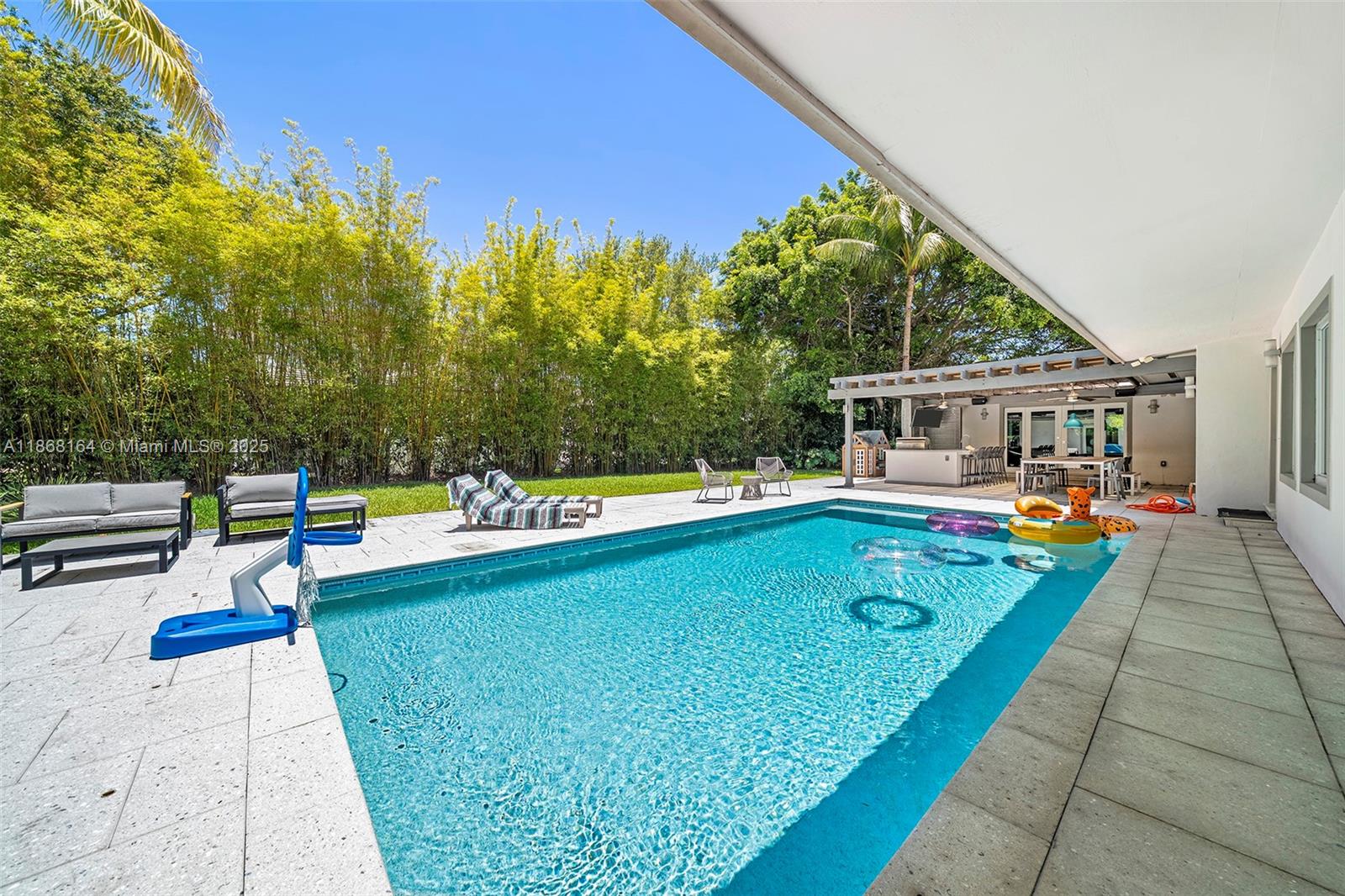 11001 Southwest 64th Avenue Pinecrest, FL 33156 - Photo 13 of 37 a view of swimming pool with lounge chair and large trees