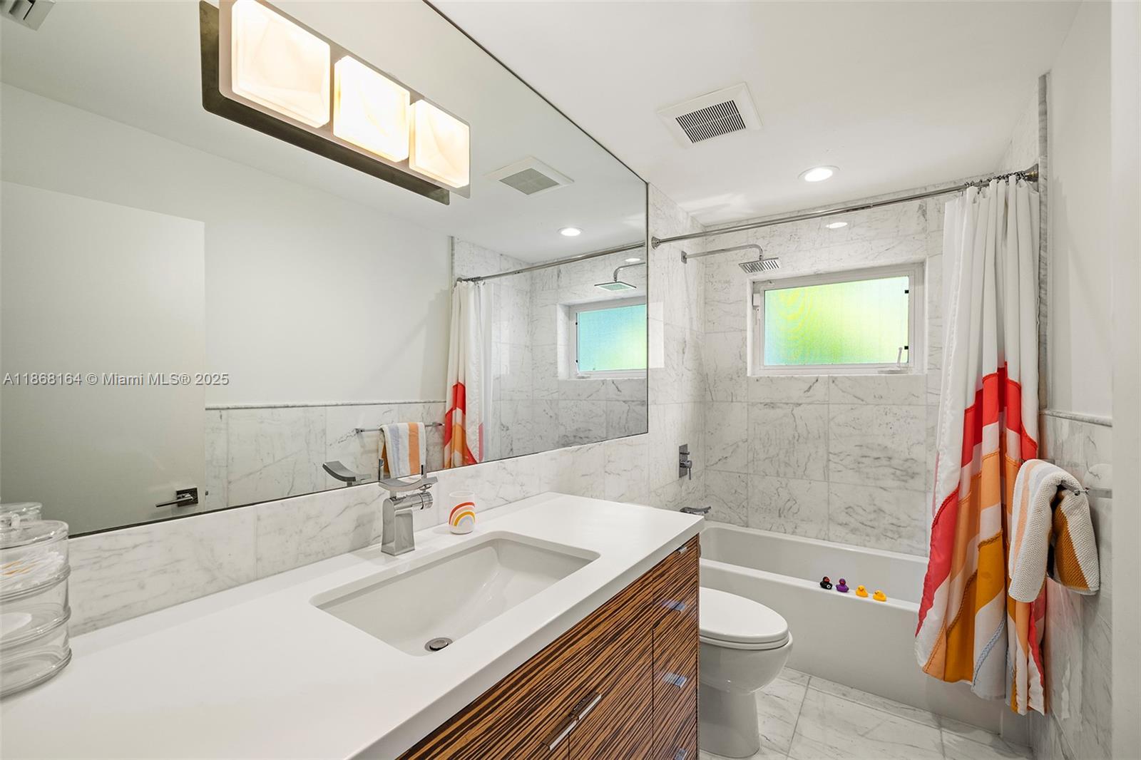 11001 Southwest 64th Avenue Pinecrest, FL 33156 - Photo 26 of 37 a bathroom with a sink and a mirror