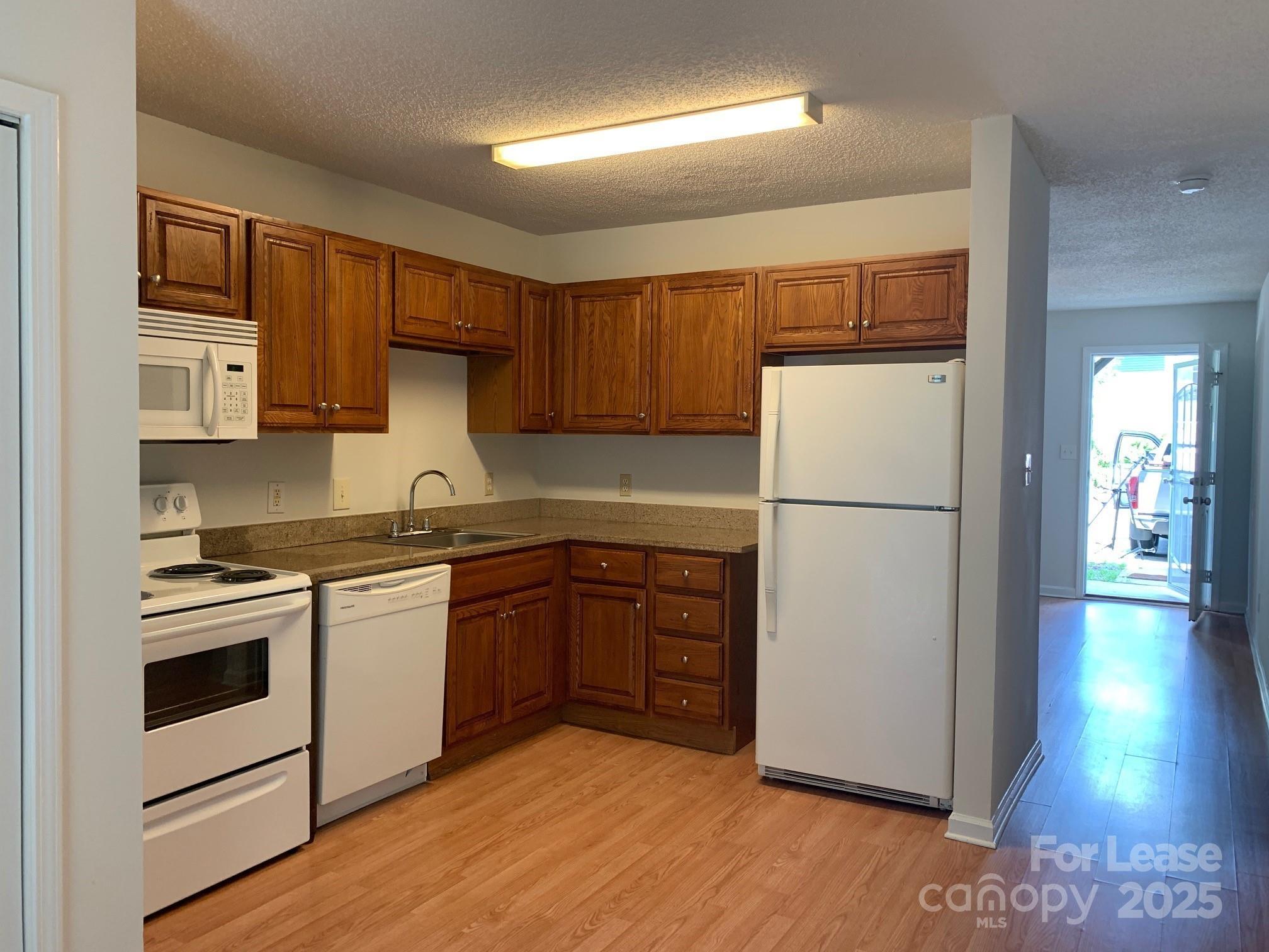 56 Tribune Avenue Southwest, Unit C Concord, NC 28025 - Photo 2 of 11 a kitchen with stainless steel appliances granite countertop a refrigerator sink and stove