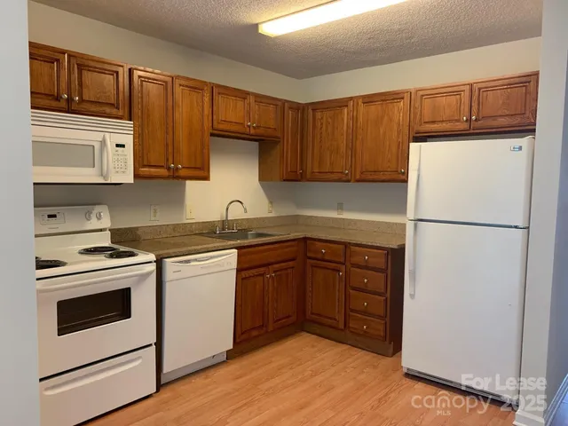 a kitchen with stainless steel appliances granite countertop a refrigerator stove a sink and dishwasher