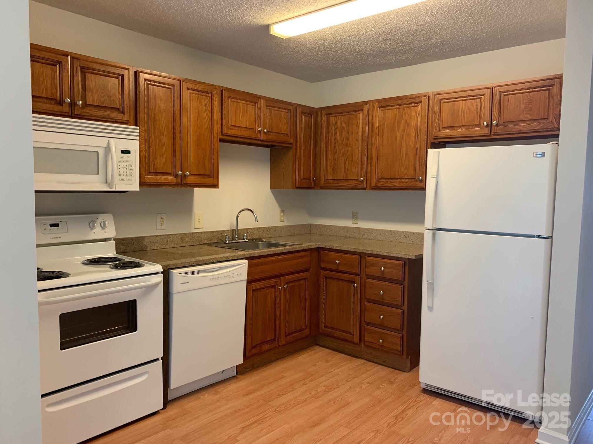 56 Tribune Avenue Southwest, Unit C Concord, NC 28025 - Photo 3 of 11 a kitchen with stainless steel appliances granite countertop a refrigerator stove a sink and dishwasher