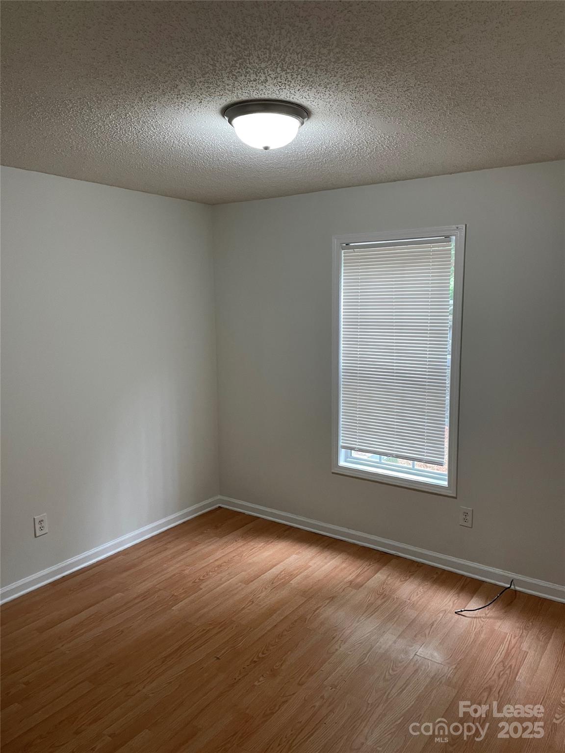 56 Tribune Avenue Southwest, Unit C Concord, NC 28025 - Photo 5 of 11 an empty room with wooden floor and windows