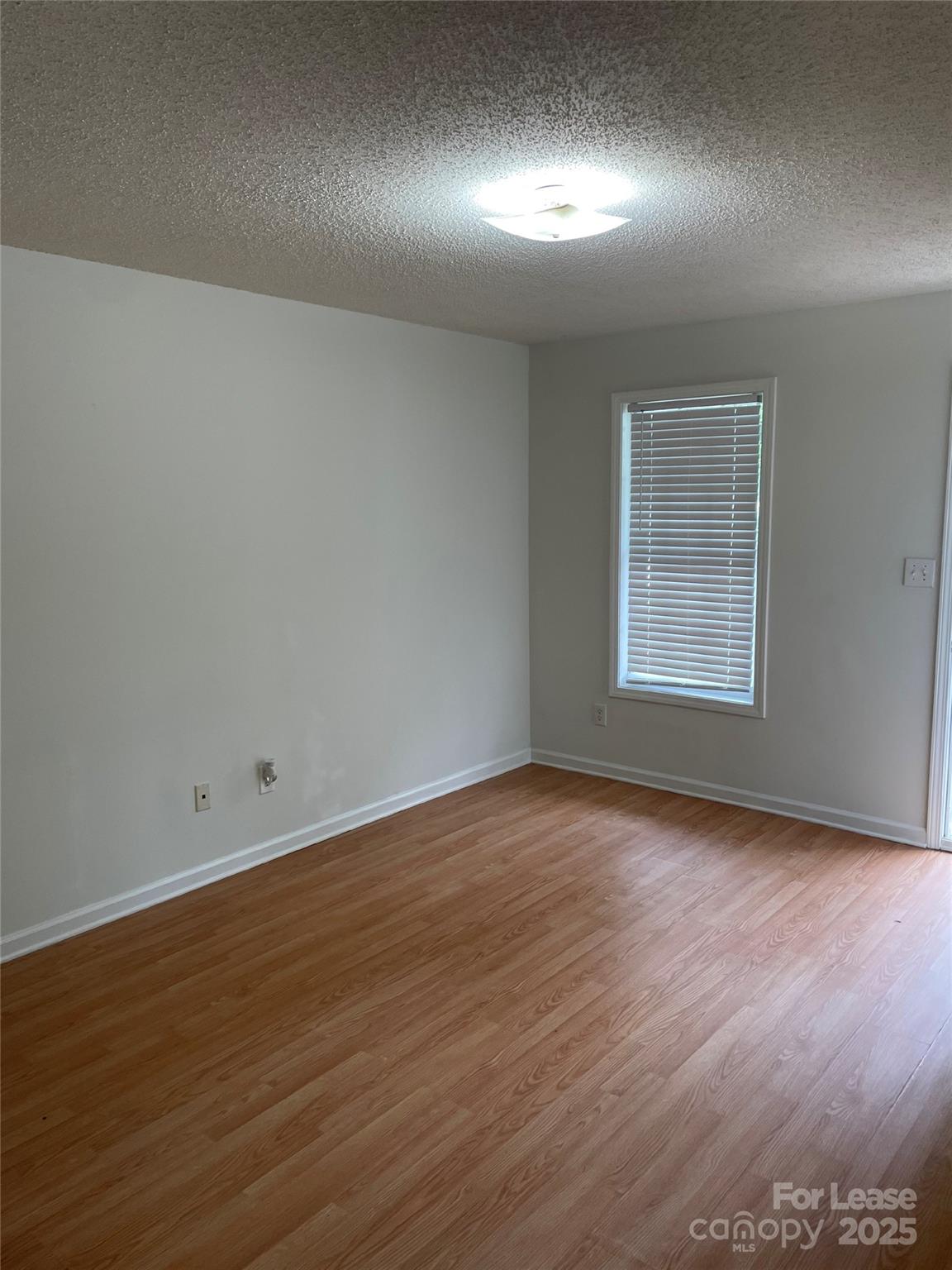 56 Tribune Avenue Southwest, Unit C Concord, NC 28025 - Photo 6 of 11 an empty room with wooden floor and windows