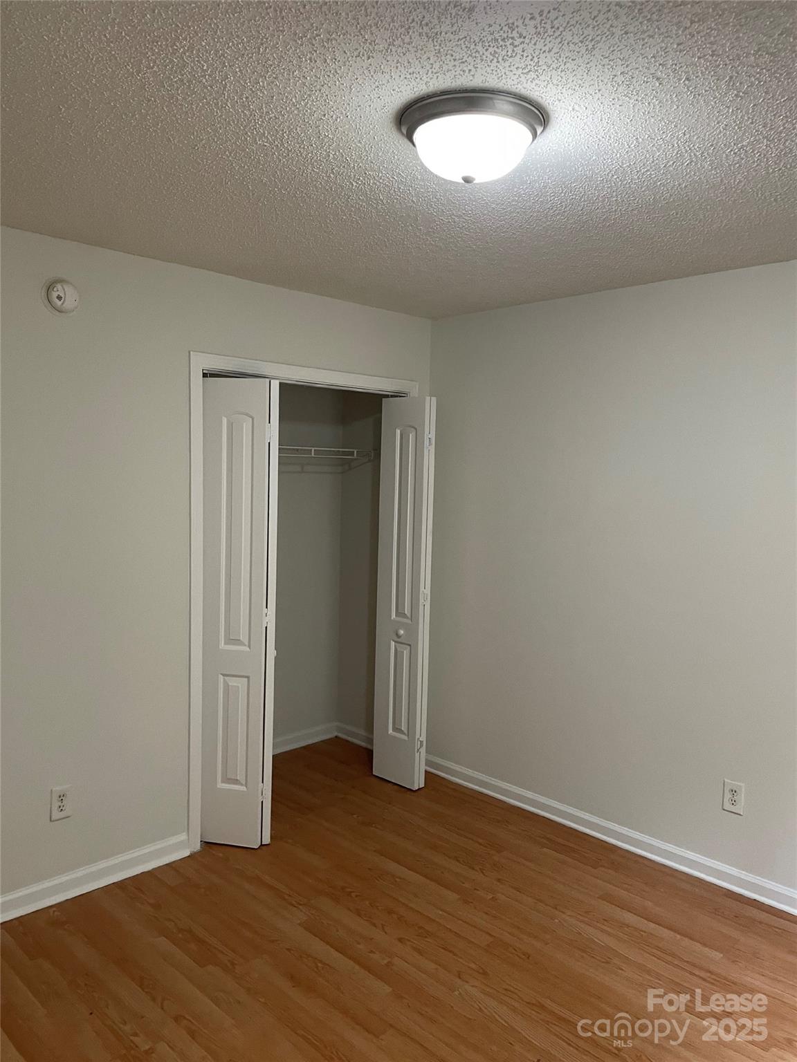 56 Tribune Avenue Southwest, Unit C Concord, NC 28025 - Photo 7 of 11 an empty room with wooden floor and windows