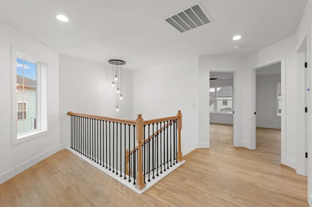 a view of a room with wooden floor & windows