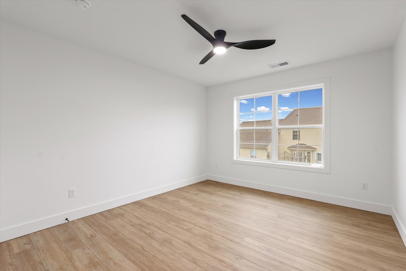 3712 Lighthouse Pointe Champaign, IL 61822 - Photo 24 of 36 an empty room with wooden floor ceiling fan and windows