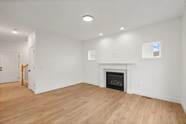 a view of empty room with wooden floor and fireplace