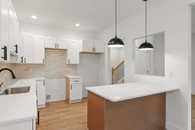 a kitchen with kitchen island a sink a stove a refrigerator and cabinets