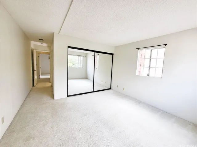 an empty room with windows and closet