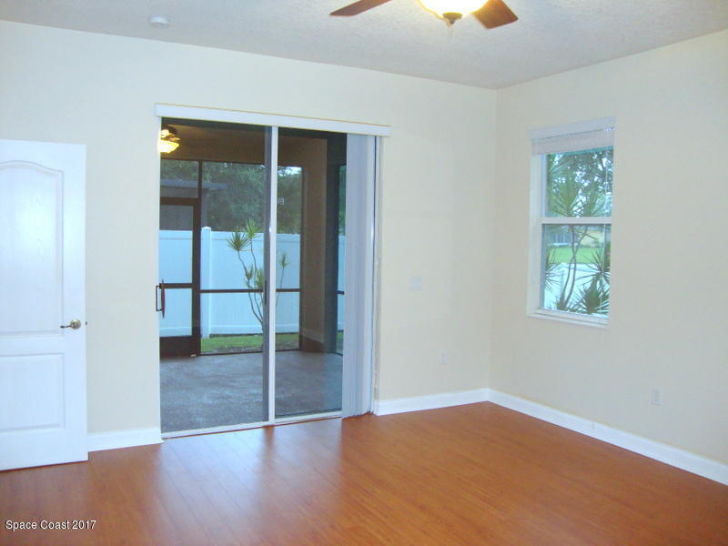 1441 Bridgeport Circle Rockledge, FL 32955 - Photo 8 of 26 an empty room with sliding door and wooden floor