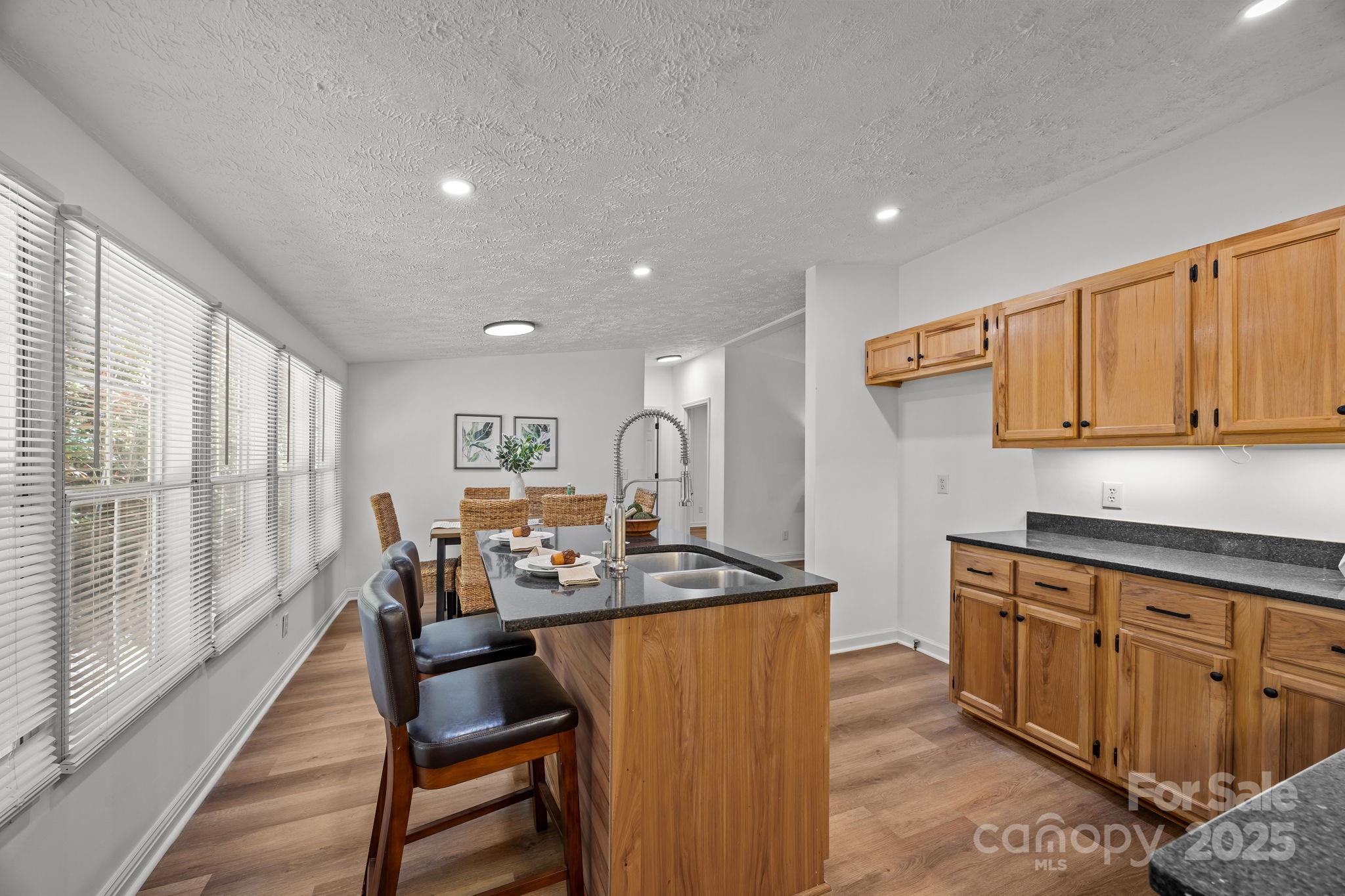 86 Tuts Terrace Sylva, NC 28779 - Photo 15 of 48 a dining hall with stainless steel appliances granite countertop a stove a sink dishwasher and a microwave with wooden cabinets