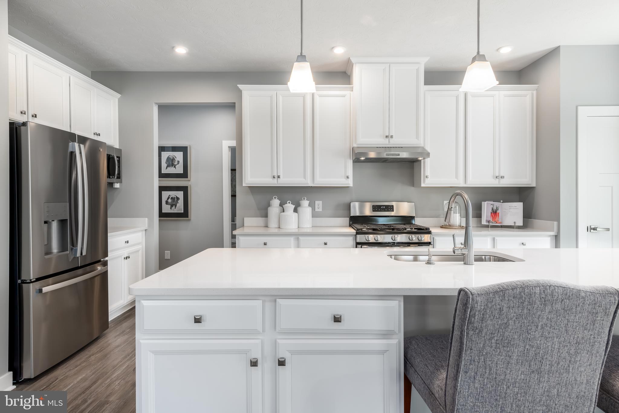 1316 Wallace Way Ranson, WV 25438 - Photo 6 of 20 a kitchen with kitchen island white cabinets and stainless steel appliances