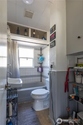 a bathroom with a toilet and a shower curtain