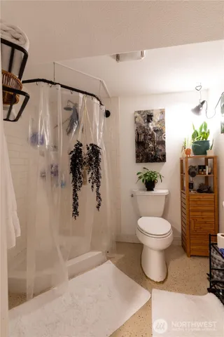 a bathroom with a toilet and a shower
