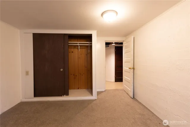 an empty room with closet and wooden door