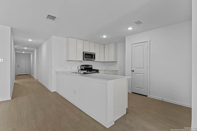 a kitchen with cabinets and a refrigerator
