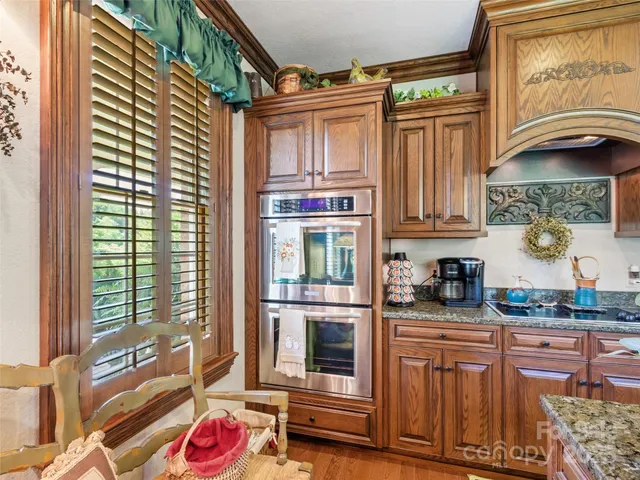 a living room with furniture two window and a wooden floor
