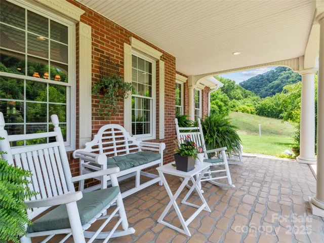 a view of a dining room with furniture a chandelier and wooden floor