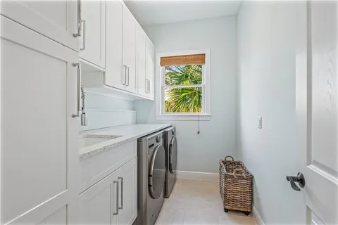 a utility room with cabinets washer and dryer